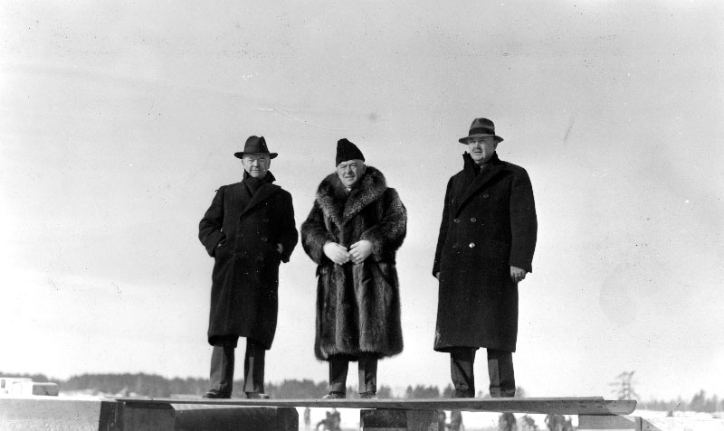 Les trois frères Simard posant sur une surface de métal.