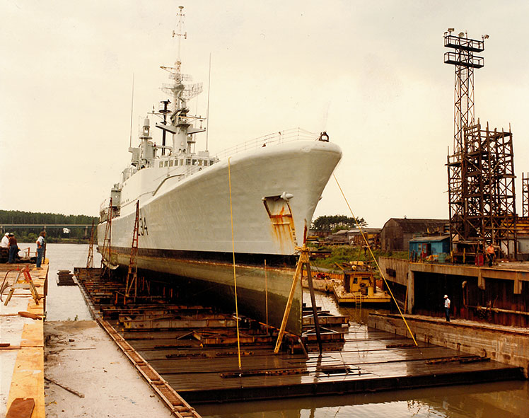Des hommes de chaque côté de la rampe de lancement où repose un navire.